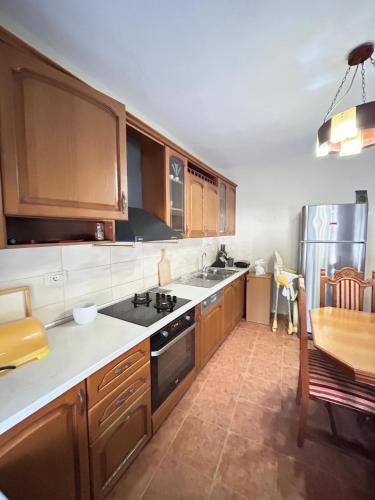 een keuken met houten kasten en een tafel erin bij Vila Koltrina in Shkodër