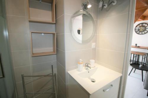 une salle de bain avec un lavabo et un miroir dans l'établissement Logement neuf à 750m de la plage, à La Tranche-sur-Mer