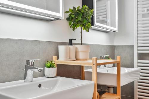 a bathroom with a sink and a shelf with a plant at Stephansdom View Big Apartment I Self-Checkin in Vienna