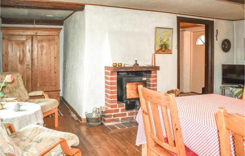 a living room with a fireplace and a table and chairs at Holiday Home Simrishamn Lxxv in Gladsax