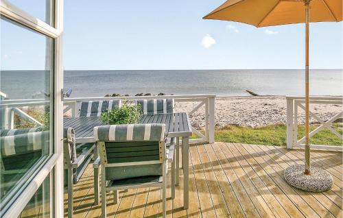 a table and chairs on a deck with the beach at Holiday Home Ny Bamsestræde O-624 in Otterup