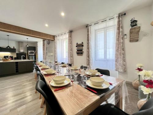 une grande table avec des chaises et une grande table avec des verres dans l'établissement La Grange de Lucien, à Meyras