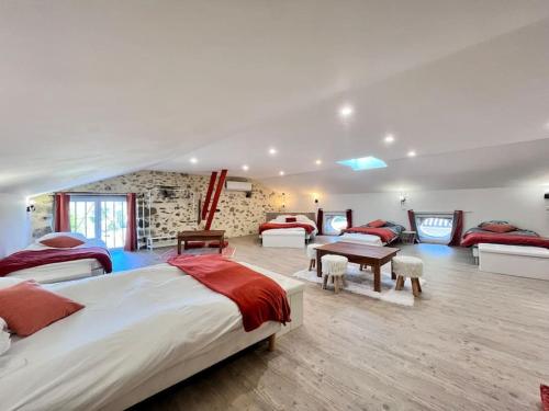 - une chambre avec 3 lits et une table dans l'établissement La Grange de Lucien, à Meyras