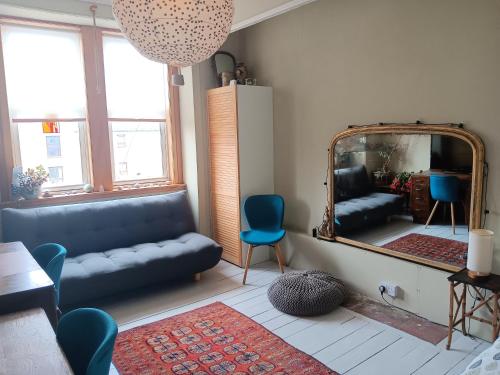 Una sala de estar con un sofá y un espejo. en King's Road - 425, en Edimburgo