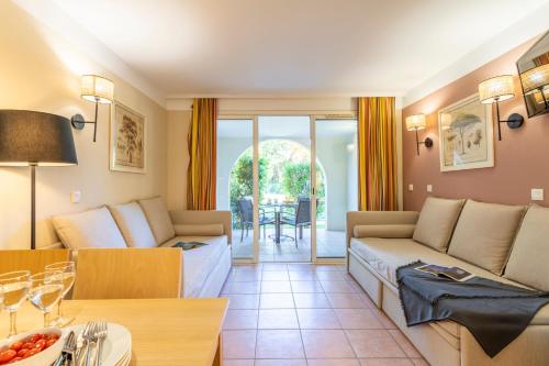 a living room with two couches and a table at Résidence Pierre & Vacances le Hameau de la Pinède in Hyères