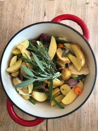 a pot of vegetables with a red handle on a table at El refugio in Reynès