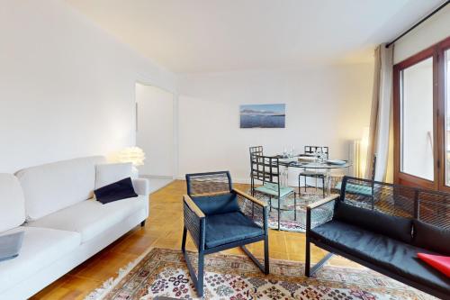 un salon avec un canapé blanc et une table en verre dans l'établissement LES MARMOTTES T4 à deux pas du lac, à Annecy