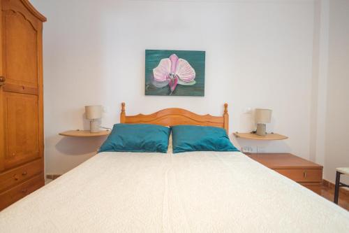 Un dormitorio con una cama con cabecero de madera. en Playa Arinaga junto al mar, en Agüimes