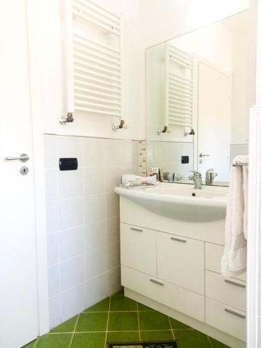 a white bathroom with a sink and a mirror at La Tortora in Cefalù