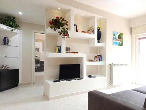 a living room with white shelves and a tv at La Tortora in Cefalù