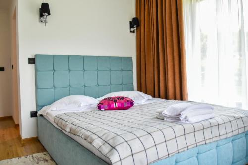 a bed with a pink bag on top of it at Vila MOON in Bezdead