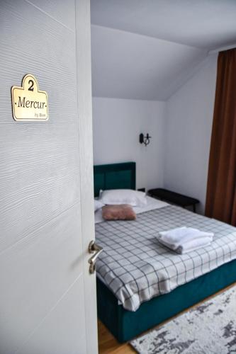 a bedroom with a bed with a sign on the door at Vila MOON in Bezdead