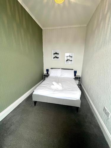 a bed in a room with two pictures on the wall at 3 BDRM close to beach&city in North Shields