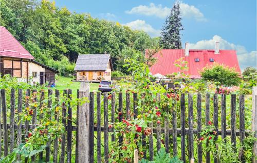 a wooden fence in front of a garden with flowers at 1 Bedroom Awesome Home In Wejherowo in Wejherowo