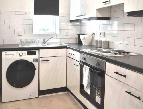 een keuken met een wasmachine en een wastafel bij Free Parking, City Centre,quiet,netflix in Town Moor