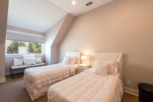 a bedroom with two beds and a window at Villa Bridgehampton village in East Hampton