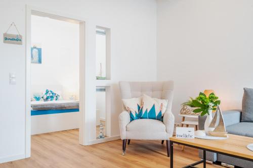 a living room with a chair and a mirror at App 8u Heimatliebe in Dranske