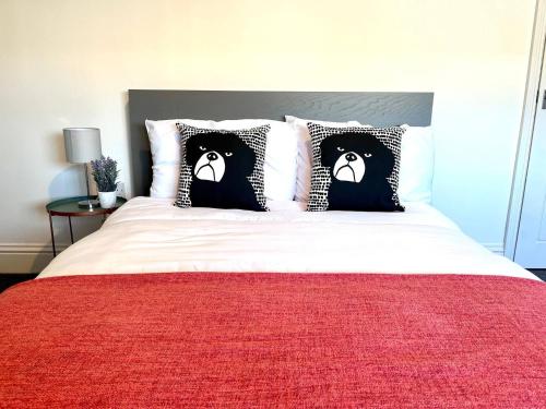 アシントンにあるSpacious 3 Bed Northumberland Long Stay Discountの黒と白の枕が付いたベッドのある寝室