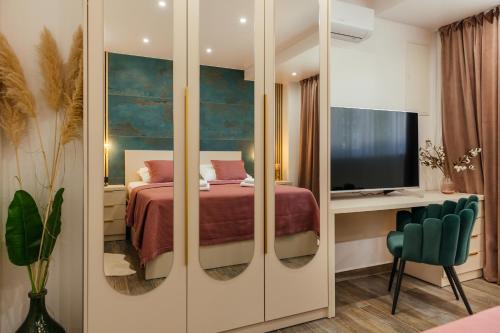 a bedroom with a bed and a television in a room at VILLA G., Relaxing and Unique nest of Enjoyment in Imotski