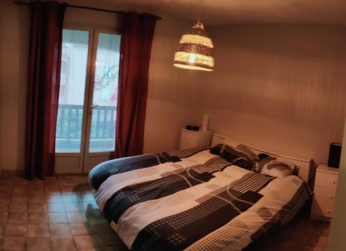 une chambre avec un lit, une fenêtre et un lustre dans l'établissement Villa Six-Fours Les Plages, à Six-Fours-les-Plages