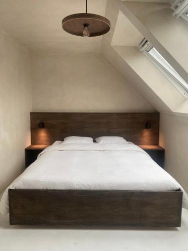 a bedroom with a large bed with a wooden headboard at Edville Studio in Ghent