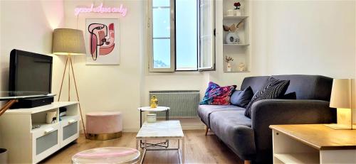 un salon avec un canapé et une télévision dans l'établissement “ BonJour” Au cœur et au calme, à Cannes