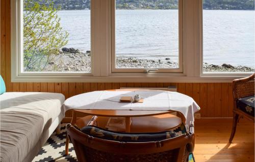 a room with two beds and a table and two windows at 1 Bedroom Stunning Home In Sætre in Sætre