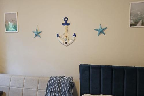 a living room with a couch and three stars on the wall at Ground floor Studio in Golem Next to Hotel Flower self check in 100m to beach in Golem