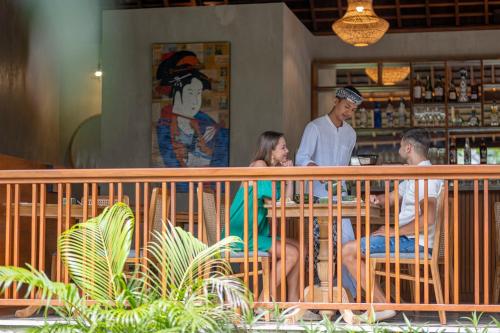 a group of people sitting at a table in a restaurant at Unagi Wooden Villas by Emana in Ubud