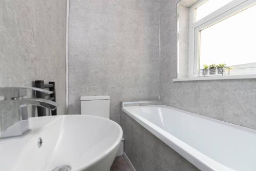 a white bathroom with a tub and a sink at Cosy Home In Darlington in Darlington