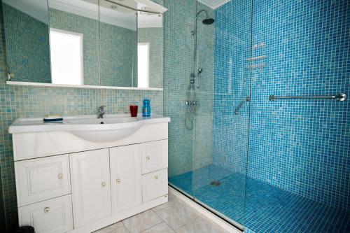 a bathroom with a sink and a shower with blue tiles at Maison familiale avec jacuzzi, quartier calme in Avignon