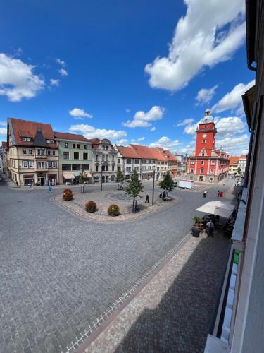 a town square with a red building and a clock tower at CozyHome Hauptmarkt Apartments in Gotha