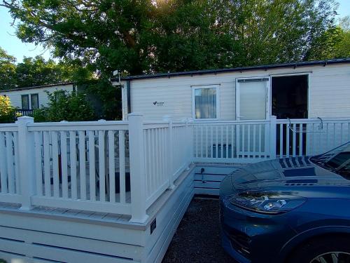 a white house with a fence and a car at Sleeps 6 Pets Allowed & Free Parking in Weymouth