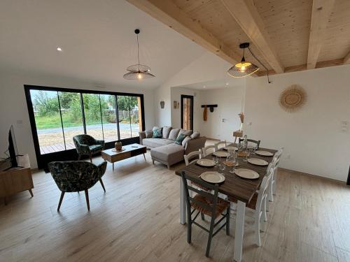 un salon avec une table et un canapé dans l'établissement Maison du Bois, pinède et océan, à Saint-Jean-de-Monts