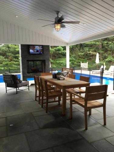 a patio with a table and chairs and a pool at Villa Bridgehampton village in East Hampton