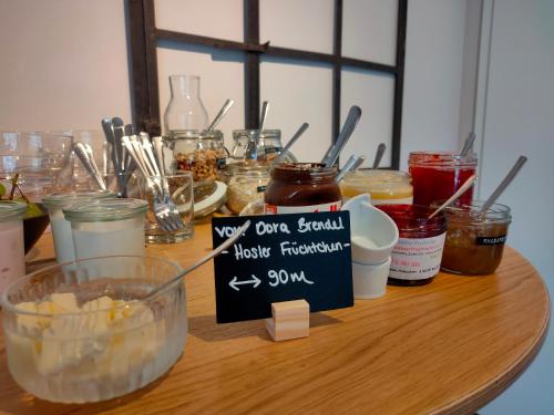 a table with jars of food and a sign on it at das herzstück - Schaubrennerei, Hausbrauerei & Apartments in Burghaslach