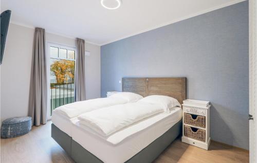 ein Schlafzimmer mit einem großen Bett mit weißen Laken und einem Fenster in der Unterkunft Baltischer Hof Apartment 42 in Boltenhagen