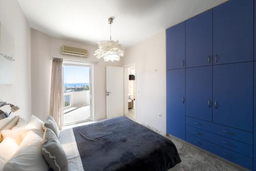 una camera da letto con armadi blu e un letto con finestra di Karystos Mare Apartments a Karistos