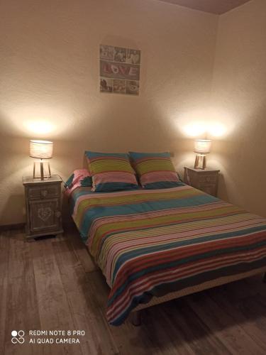 une chambre avec un lit avec deux lampes dessus dans l'établissement Gîte Bégonia dans un cadre idyllique, idéalement situé, à Castels