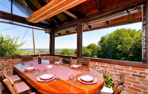 a dining room with a table and chairs and large windows at Awesome Home In Ludbreg in Ludbreg