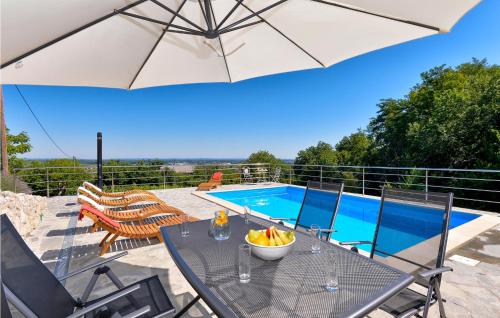 a patio with a table with an umbrella and a pool at Awesome Home In Ludbreg in Ludbreg