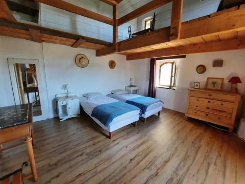 une chambre avec deux lits et un parquet dans l'établissement Le Mas du Tes, à Saint-Sèbastien