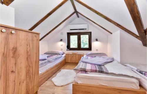two twin beds in a attic bedroom with a window at Awesome Home In Ludbreg in Ludbreg