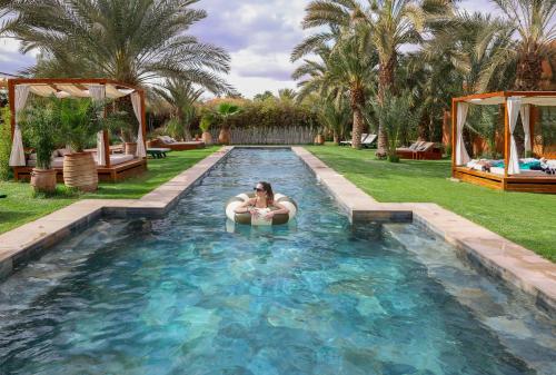 a woman in a swimming pool in a backyard at Domaine Des Remparts Hotel & Spa in Marrakech