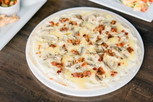 a white bowl of food with mushrooms on a wooden table at Zuri Hotel in Iloilo City