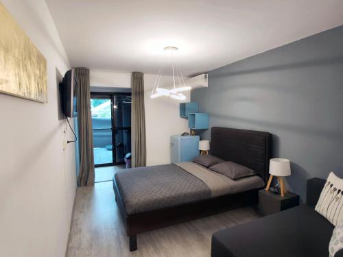 a small bedroom with a bed and a couch at ALFA BETA RESIDENCE in Saturn