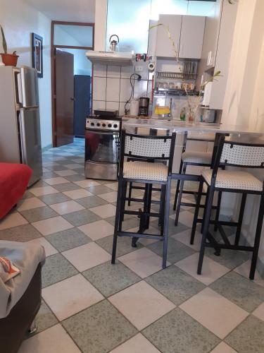 a kitchen with a counter with chairs and a refrigerator at Just for me in Lima