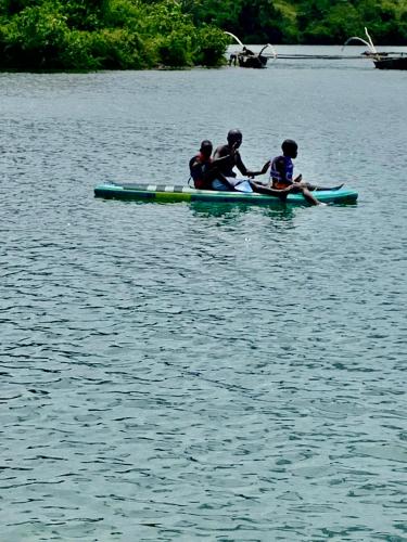 three people in a kayak on a body of water at Inzozi Eco Camp in Gishyita