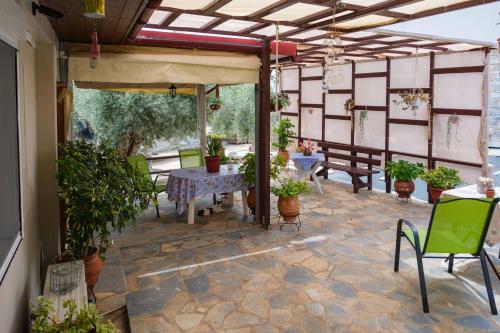 a patio with a table and chairs and potted plants at Effie's Maisonette with Detached Studio in Amaliápoli