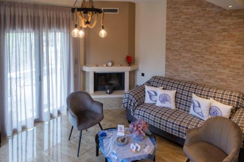 a living room with a couch and chairs and a fireplace at Effie's Maisonette with Detached Studio in Amaliápoli